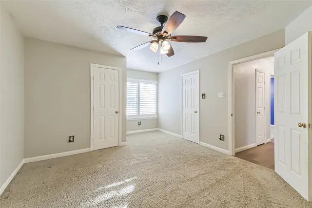 a view of an empty room with a ceiling fan