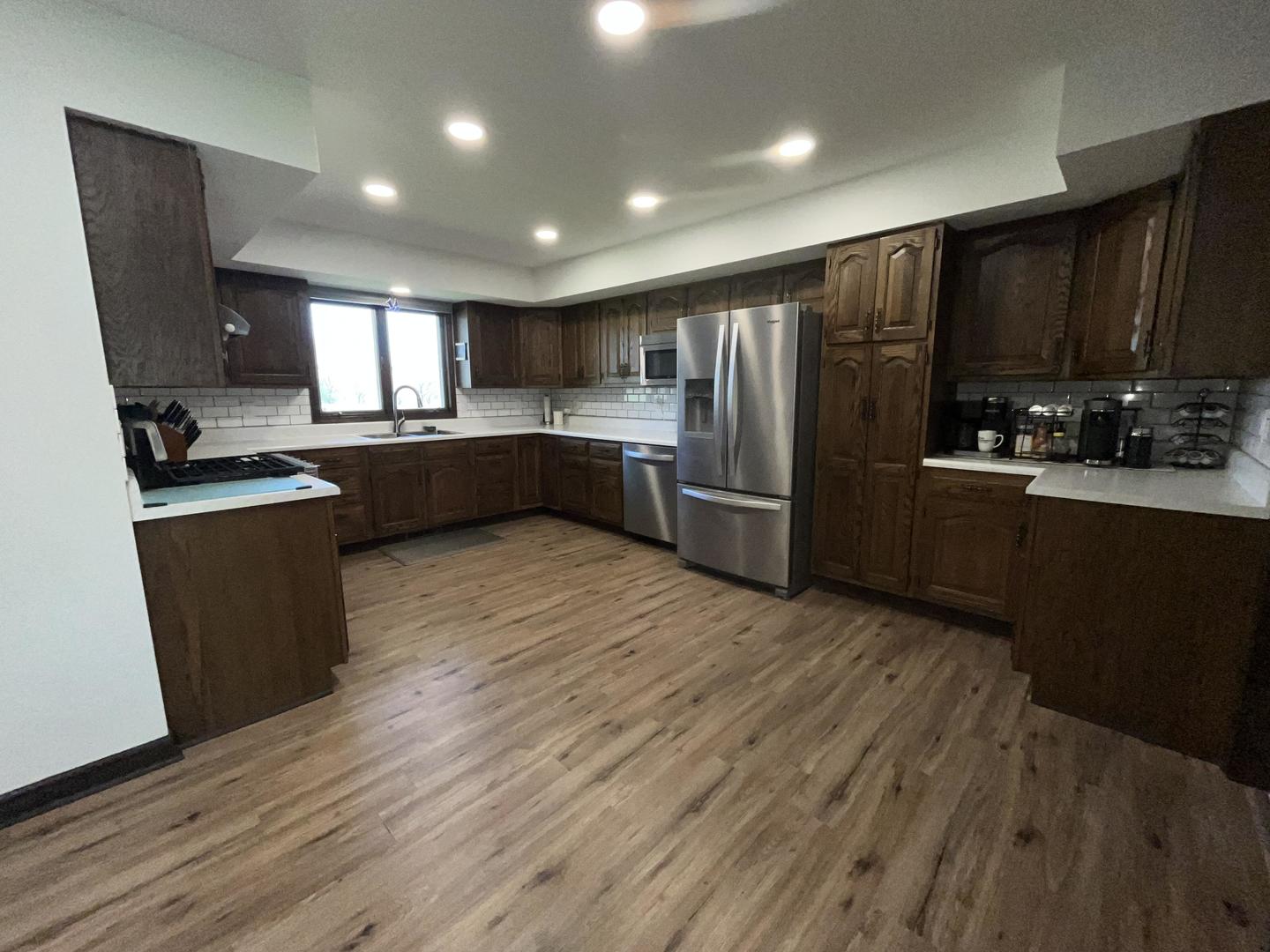 57 Jibby Estates Sullivan, IL 61951 - Photo 2 of 16 a kitchen with stainless steel appliances kitchen island granite countertop a refrigerator a sink dishwasher a stove and a microwave oven with wooden floor