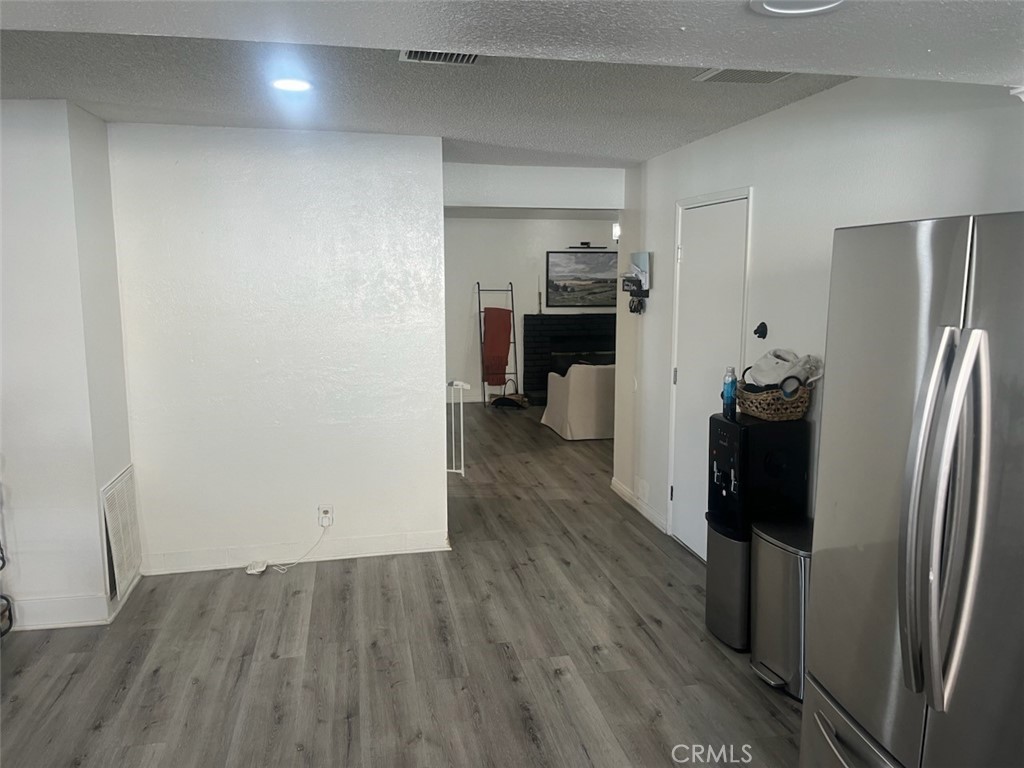 44706 Sarah Lane Lancaster, CA 93535 - Photo 9 of 17 a view of a refrigerator in kitchen and an empty room with wooden floor windows
