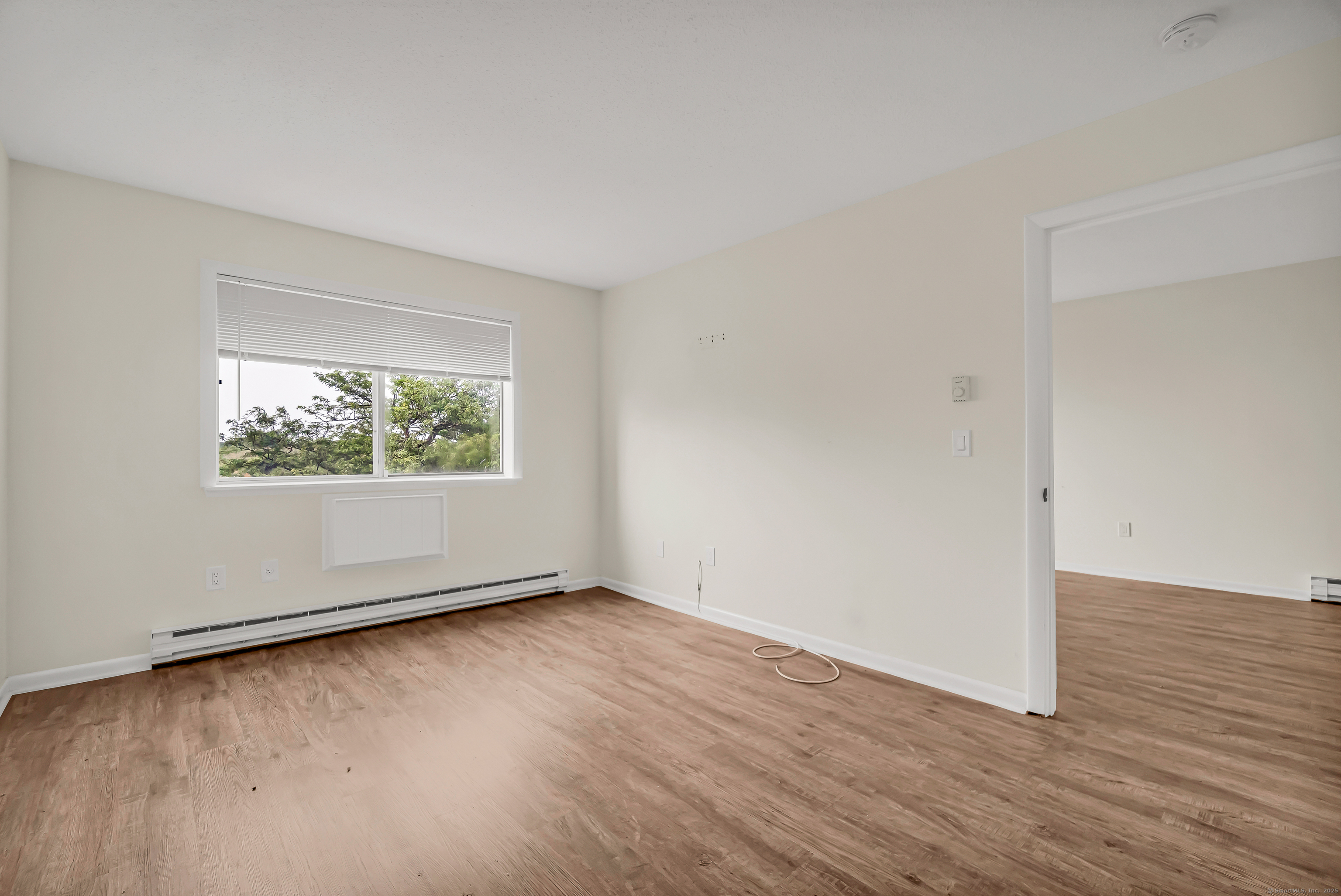 115 Short Beach Road, Unit 104 Stratford, CT 06615 - Photo 11 of 19 an empty room with wooden floor and windows
