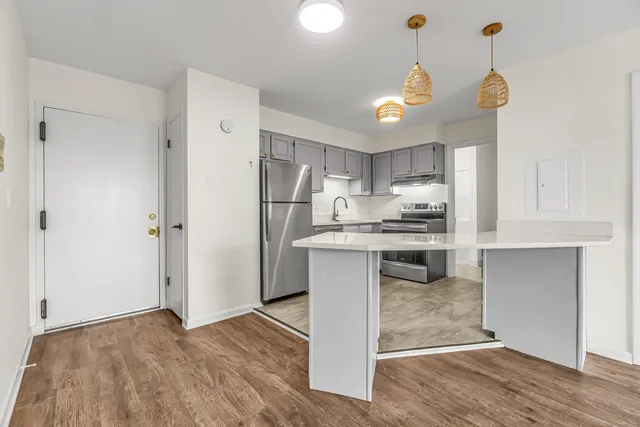 a kitchen with kitchen island white cabinets and stainless steel appliances