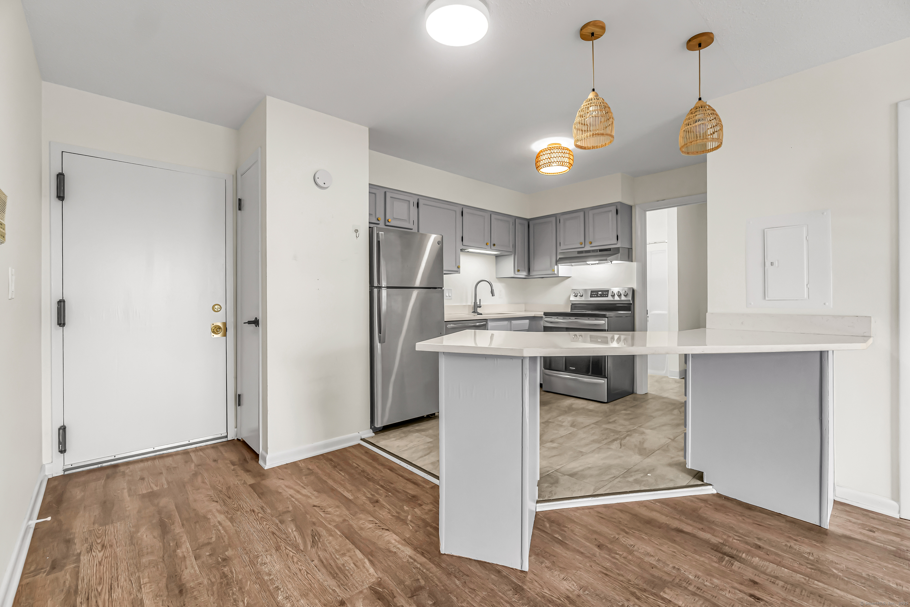 115 Short Beach Road, Unit 104 Stratford, CT 06615 - Photo 5 of 19 a kitchen with kitchen island white cabinets and stainless steel appliances
