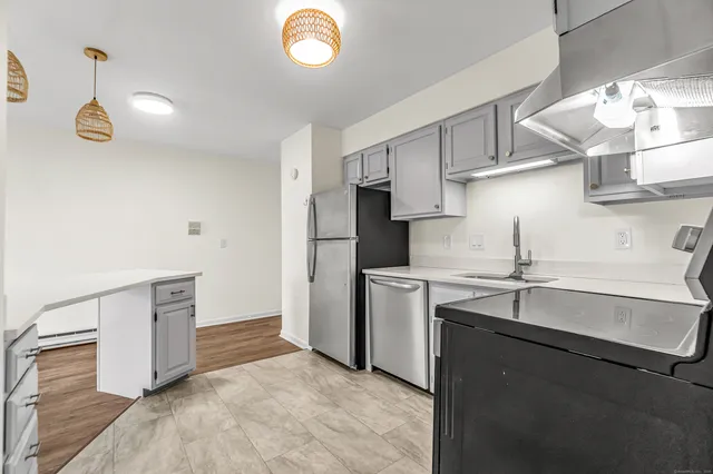 a kitchen with stainless steel appliances granite countertop a sink and dishwasher a refrigerator with wooden cabinets