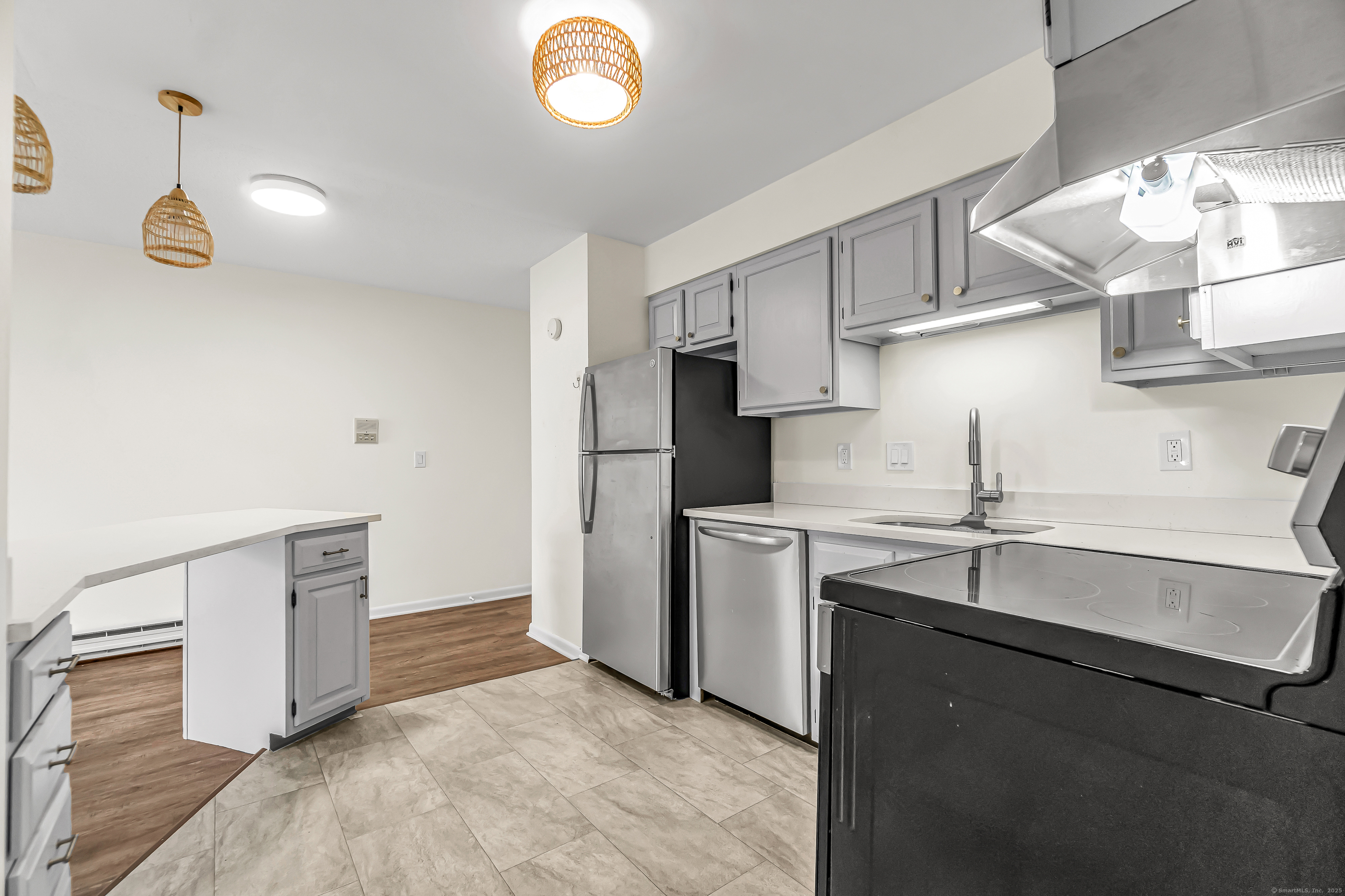 115 Short Beach Road, Unit 104 Stratford, CT 06615 - Photo 6 of 19 a kitchen with stainless steel appliances granite countertop a sink and dishwasher a refrigerator with wooden cabinets