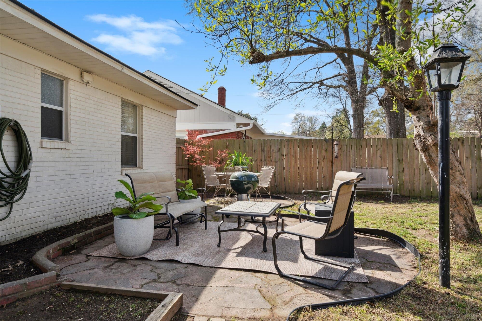 1529 Welsh Road Memphis, TN 38117 - Photo 24 of 27 a view of a patio with table and chairs potted plants and a large tree