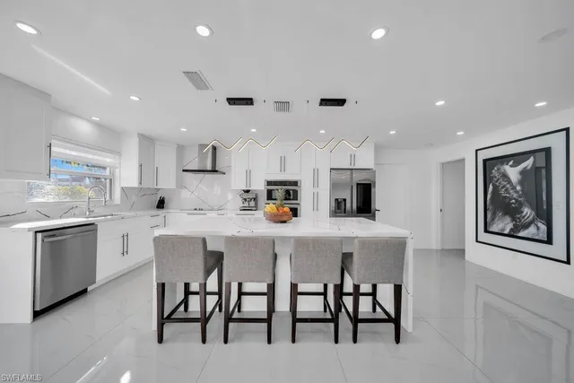 a kitchen with kitchen island cabinets and chairs in it