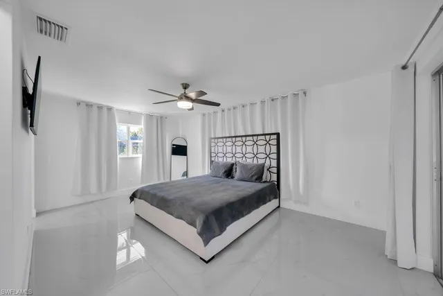 a spacious bedroom with a bed and a chandelier