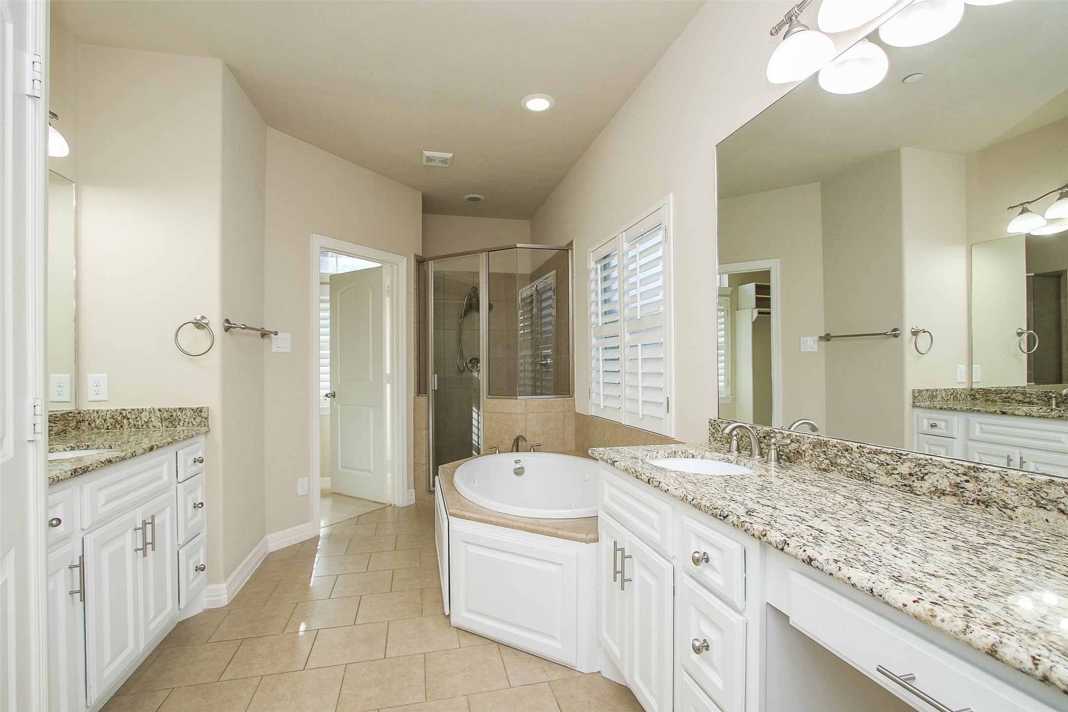 11722 Spriggs Way Houston, TX 77024 - Photo 24 of 49 Large primary bath with granite counter tops, walk in double shower head shower, jetted tub, vanity area and a linen cabinet.