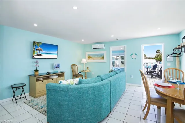 a living room with furniture and a refrigerator