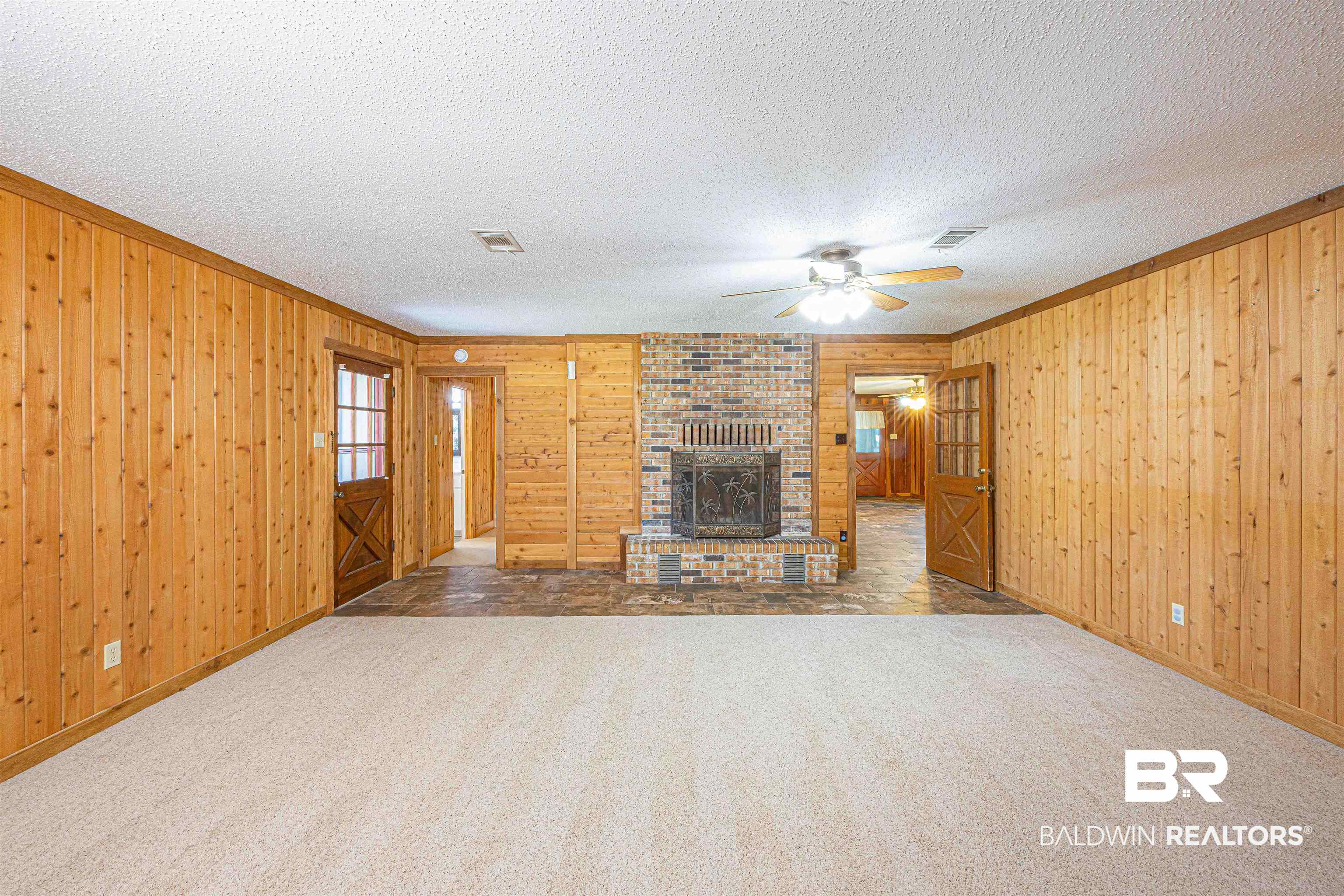 43101 Brown Road Bay Minette, AL 36507 - Photo 26 of 81 Unfurnished living room featuring crown molding, wood walls, carpet floors, a textured ceiling, and ceiling fan