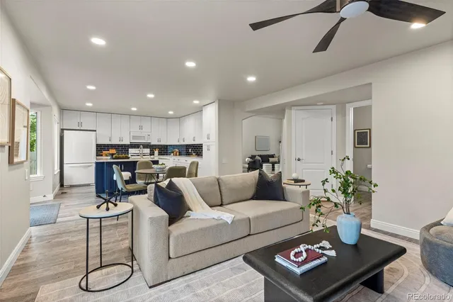 a living room with furniture and kitchen view with wooden floor