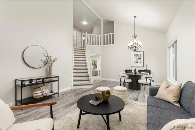 a living room with furniture a chandelier and a lamp