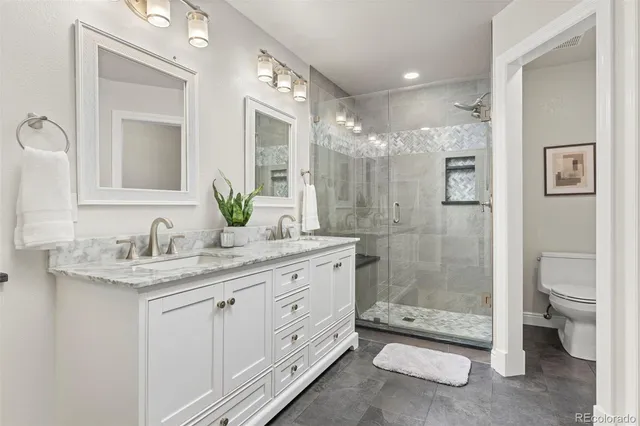 a bathroom with a granite countertop sink toilet and shower