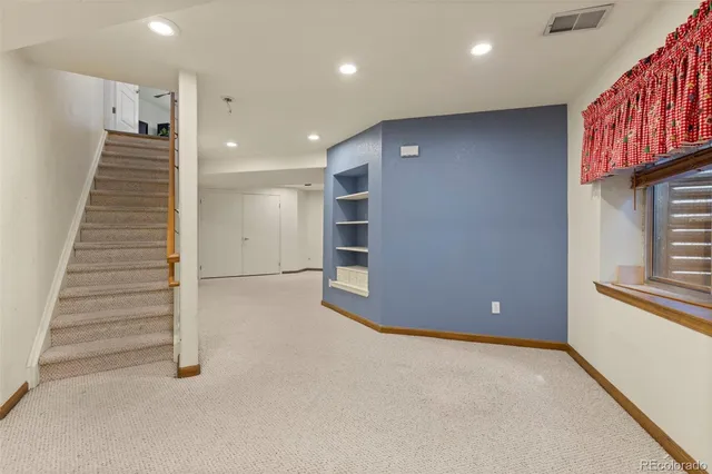 an empty room with windows and stairs