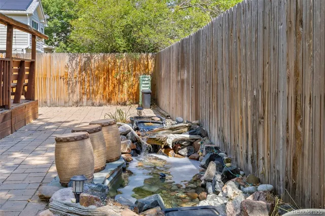 a view of a patio with table and chairs with wooden fence