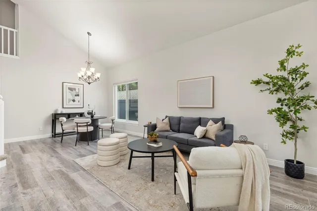 a living room with furniture a chandelier and a potted plant