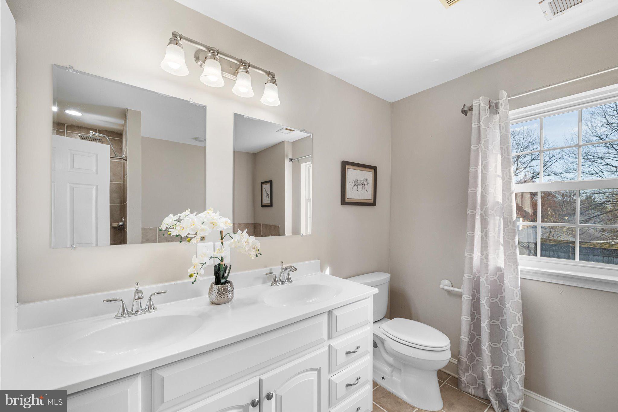 7312 Falmouth Street Springfield, VA 22150 - Photo 25 of 41 a bathroom with a double vanity sink toilet and a mirror