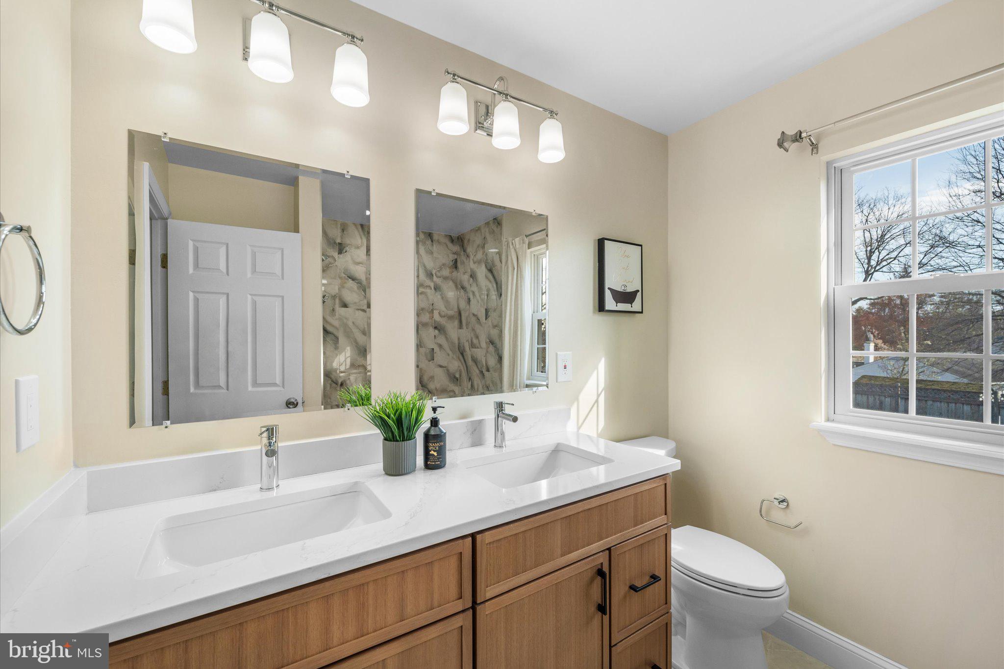 7312 Falmouth Street Springfield, VA 22150 - Photo 31 of 41 a bathroom with a granite countertop sink a toilet and a large mirror