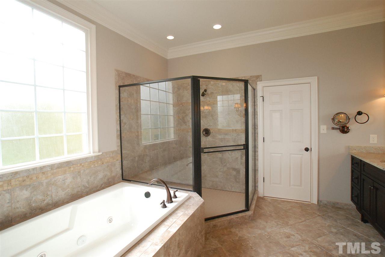 1093 Tacketts Pond Drive Raleigh, NC 27614 - Photo 12 of 25 a bathroom with a tub a sink and a large window