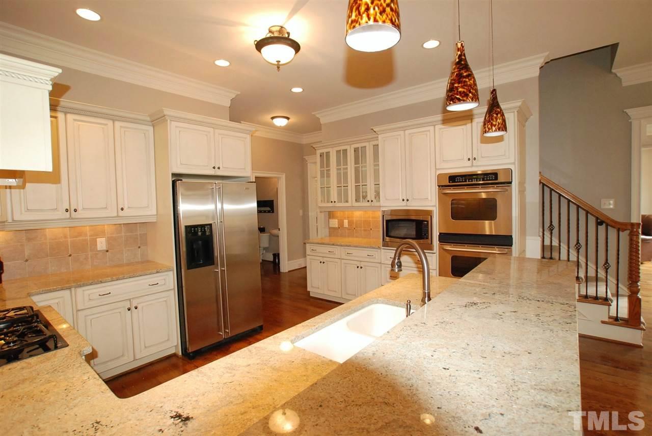 1093 Tacketts Pond Drive Raleigh, NC 27614 - Photo 9 of 25 a kitchen with stainless steel appliances kitchen island granite countertop a refrigerator and a stove top oven
