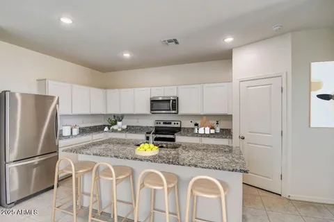 a kitchen with stainless steel appliances granite countertop a refrigerator a stove and a sink