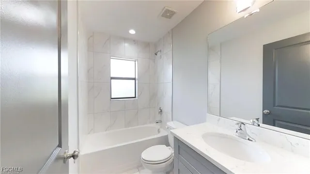a bathroom with a bathtub shower sink vanity and toilet
