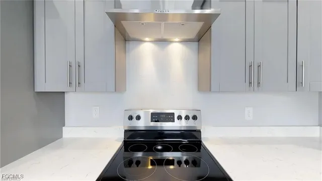 a kitchen with a stove and white cabinets