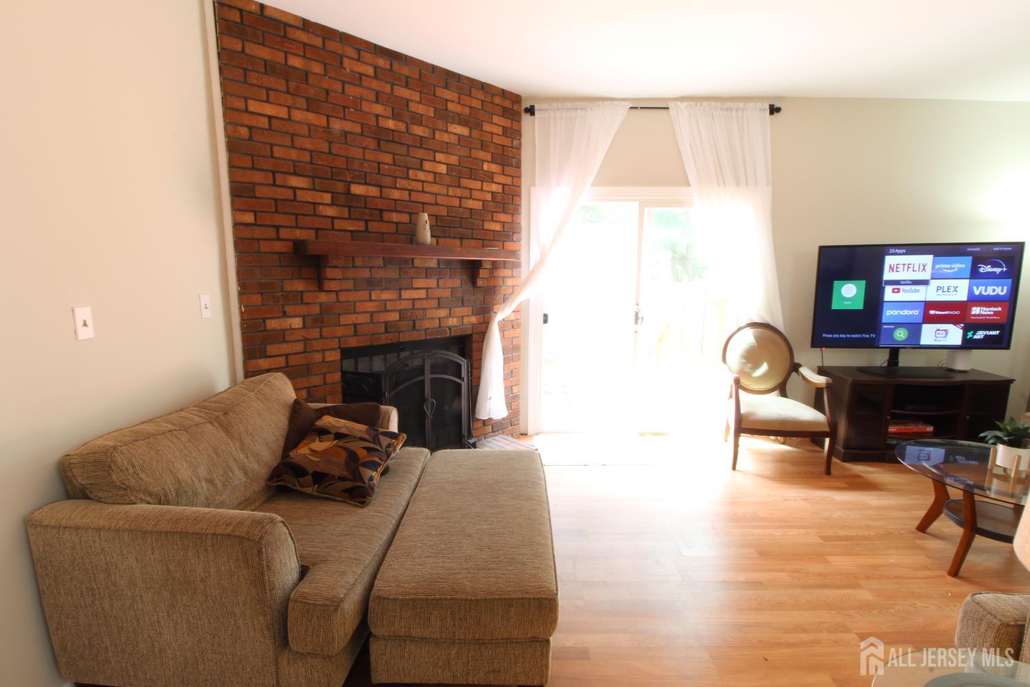 41 Brookview Circle Jamesburg, NJ 08831 - Photo 12 of 38 a living room with furniture a fireplace and a flat screen tv