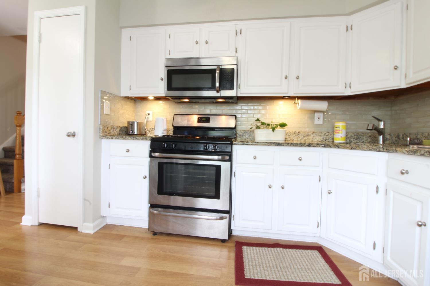 41 Brookview Circle Jamesburg, NJ 08831 - Photo 3 of 38 a kitchen with granite countertop white cabinets and stainless steel appliances