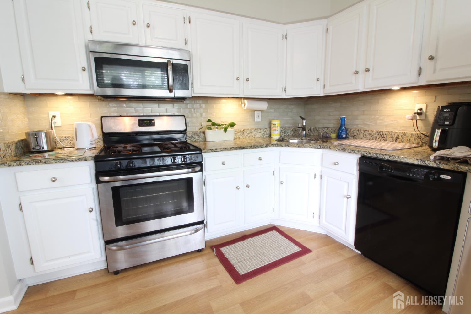 41 Brookview Circle Jamesburg, NJ 08831 - Photo 5 of 38 a kitchen with cabinets appliances and a wooden floor
