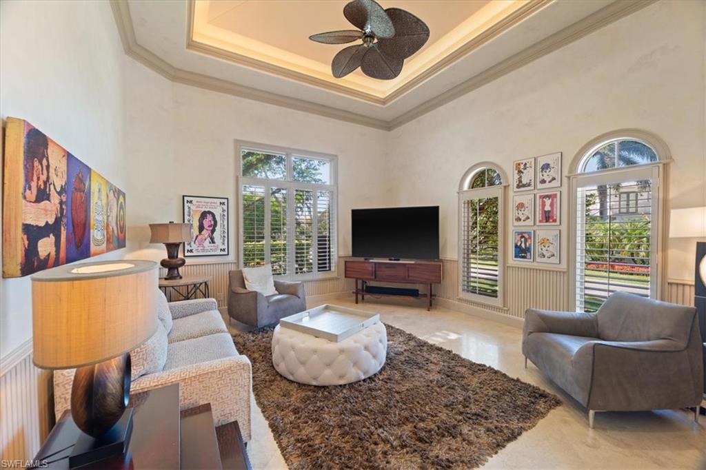 550 21st Avenue South Naples, FL 34102 - Photo 18 of 44 Den with crown molding, wainscoting, a ceiling fan, a high ceiling, and a decorative wall