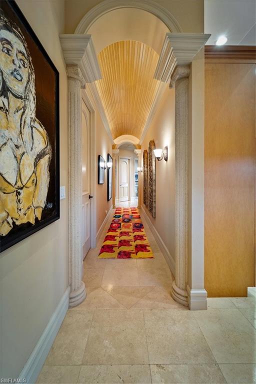 550 21st Avenue South Naples, FL 34102 - Photo 20 of 44 Hall featuring decorative columns, ornamental molding, arched walkways, and light tile patterned floors