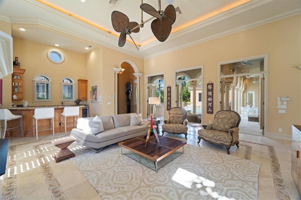 550 21st Avenue South Naples, FL 34102 - Photo 4 of 44 Living room with arched walkways, decorative columns, recessed lighting, a high ceiling, and crown molding