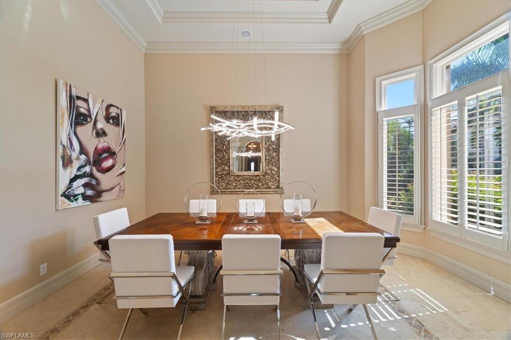 550 21st Avenue South Naples, FL 34102 - Photo 9 of 44 Dining room featuring a raised ceiling, baseboards, crown molding, and an inviting chandelier