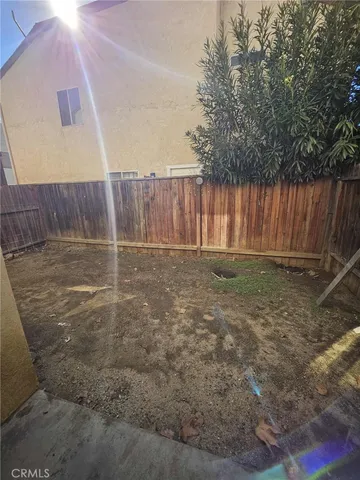 a view of backyard with wooden fence