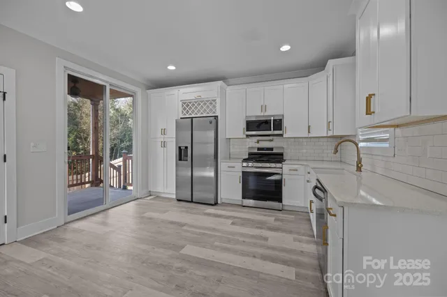 a kitchen with stainless steel appliances granite countertop a refrigerator sink and stove