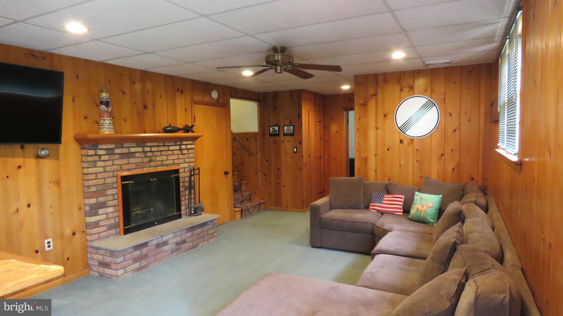 9813 Hawkins Creamery Road Damascus, MD 20872 - Photo 18 of 21 a living room with furniture a fireplace and a flat screen tv