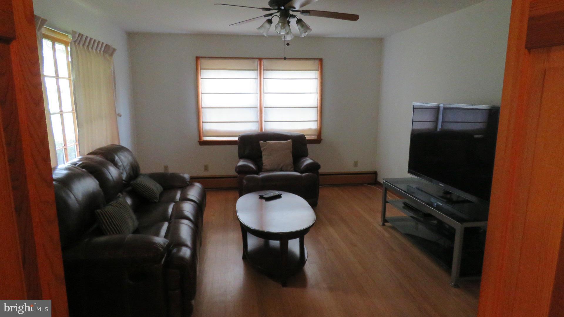 9813 Hawkins Creamery Road Damascus, MD 20872 - Photo 8 of 21 a living room with furniture a window and a flat screen tv