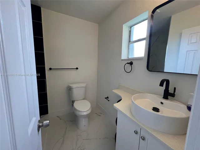 a bathroom with a sink toilet and mirror