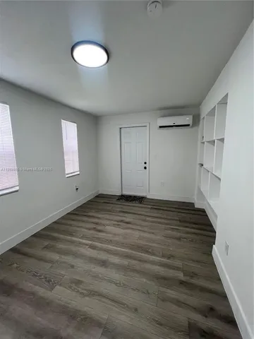 a view of a room with wooden floor and window