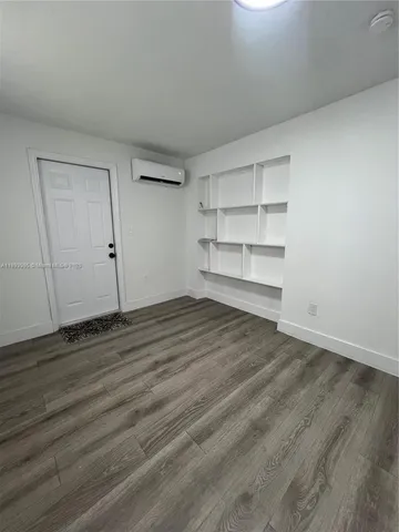 a view of empty room with wooden floor and cabinet