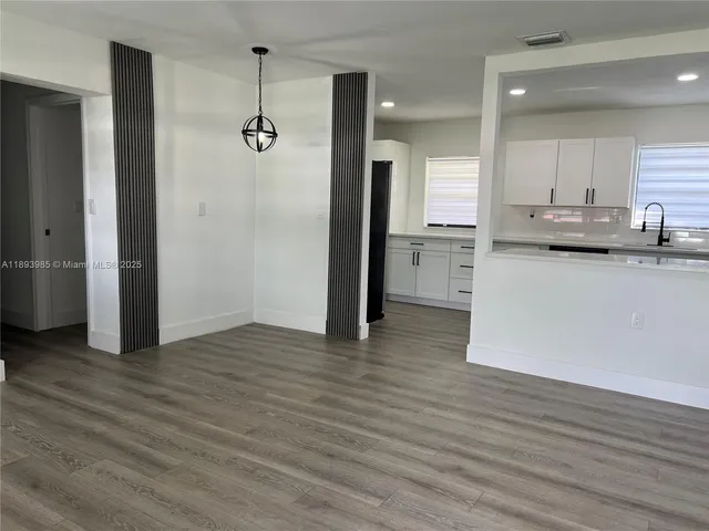 an empty room with wooden floor and cabinet
