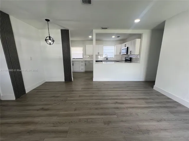 a view of a kitchen with cabinets and wooden floor