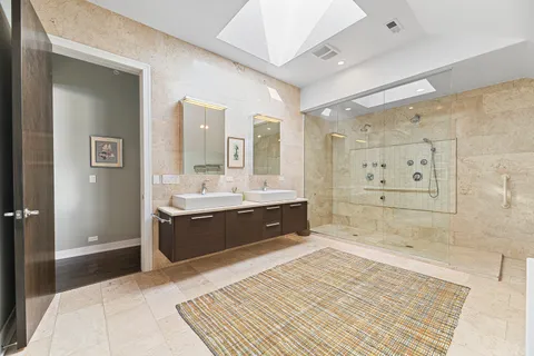 a spacious bathroom with a double vanity sink a large mirror and a shower