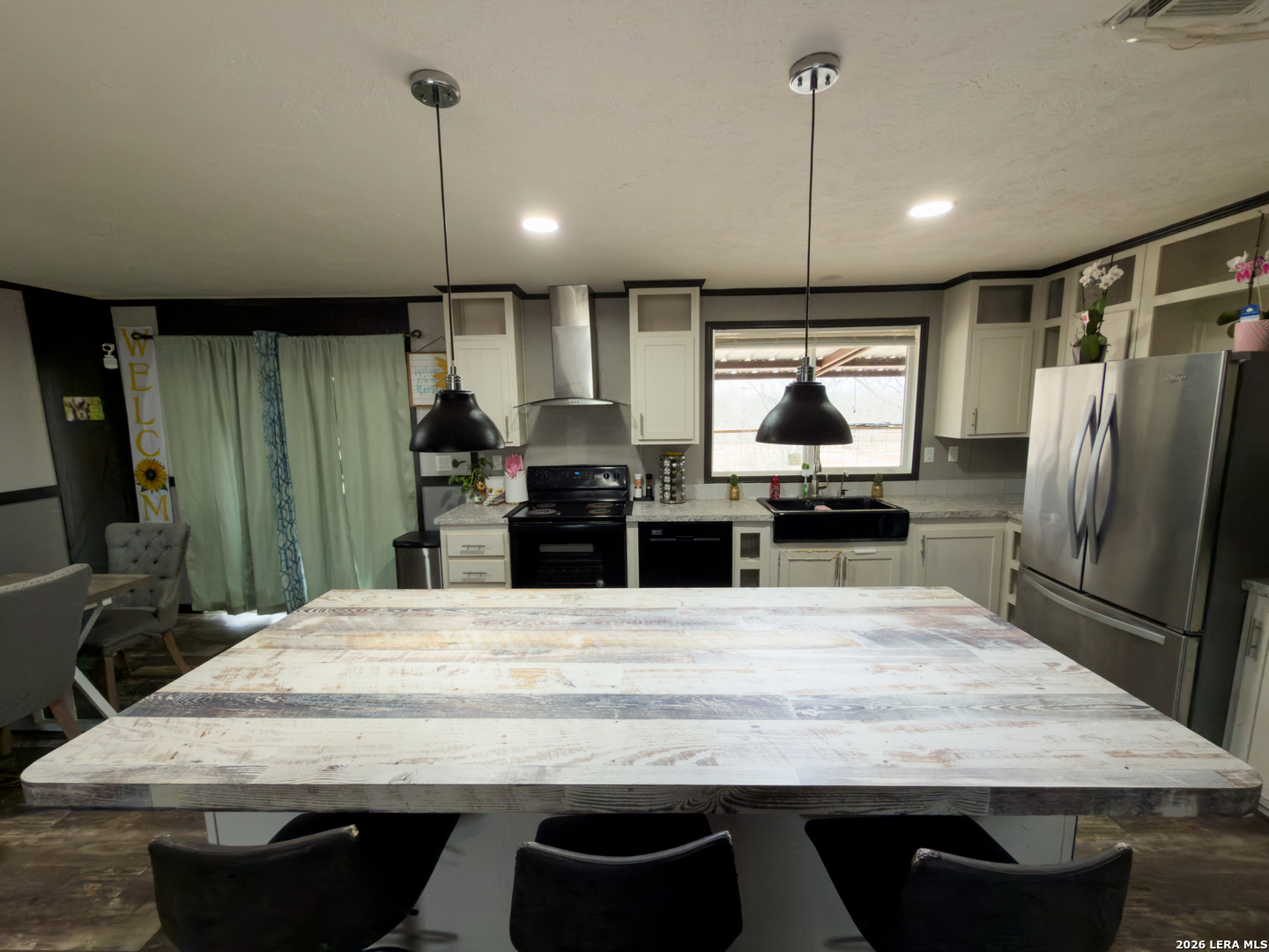 114 4th Street Natalia, TX 78059 - Photo 18 of 32 a kitchen with granite countertop a stove a sink and a refrigerator