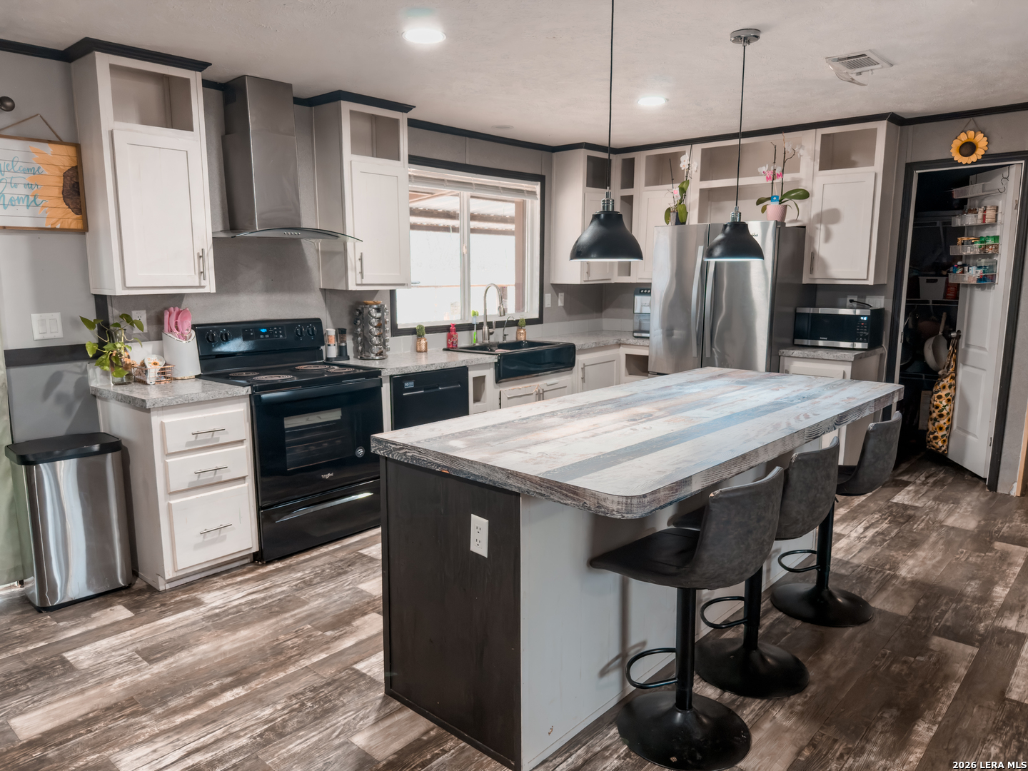 114 4th Street Natalia, TX 78059 - Photo 3 of 32 a kitchen with stainless steel appliances a stove a refrigerator and wooden cabinets