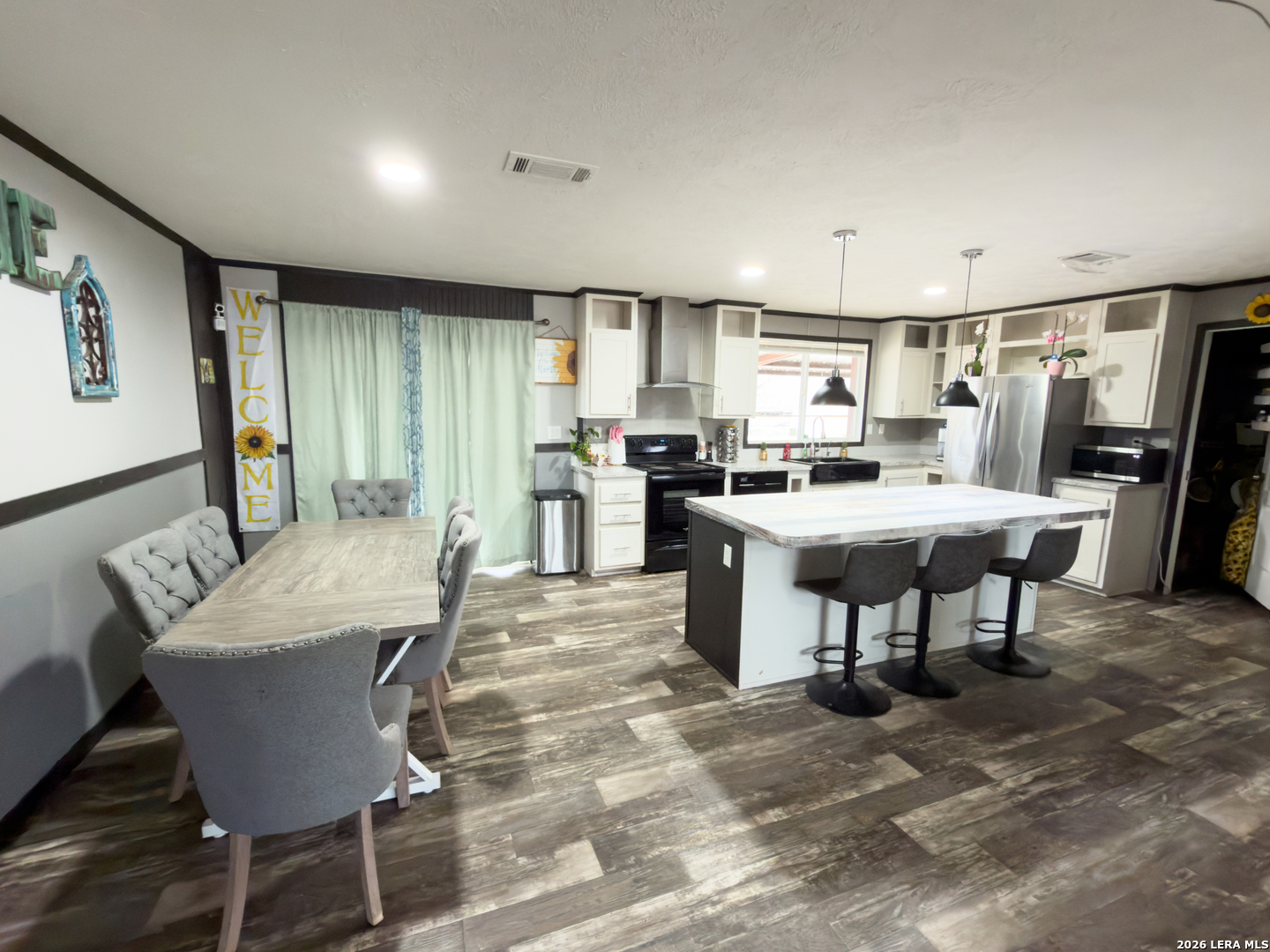 114 4th Street Natalia, TX 78059 - Photo 4 of 32 a dining hall with stainless steel appliances kitchen island granite countertop a dining table chairs and a refrigerator