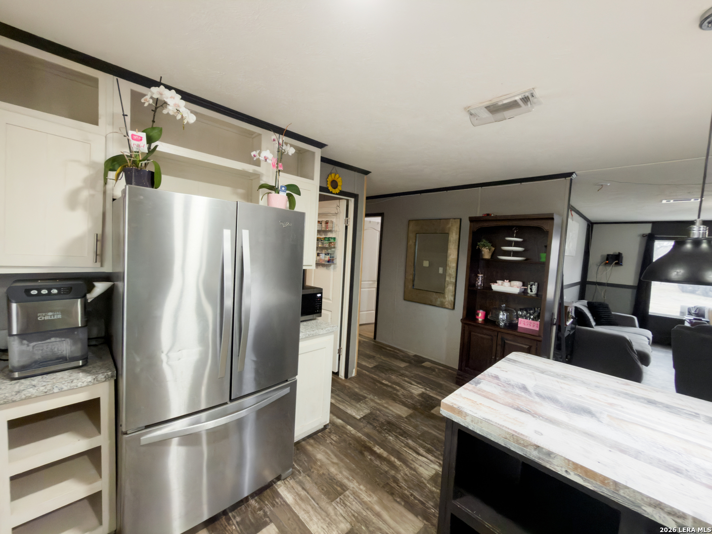 114 4th Street Natalia, TX 78059 - Photo 5 of 32 a kitchen with stainless steel appliances a refrigerator and a wooden floor