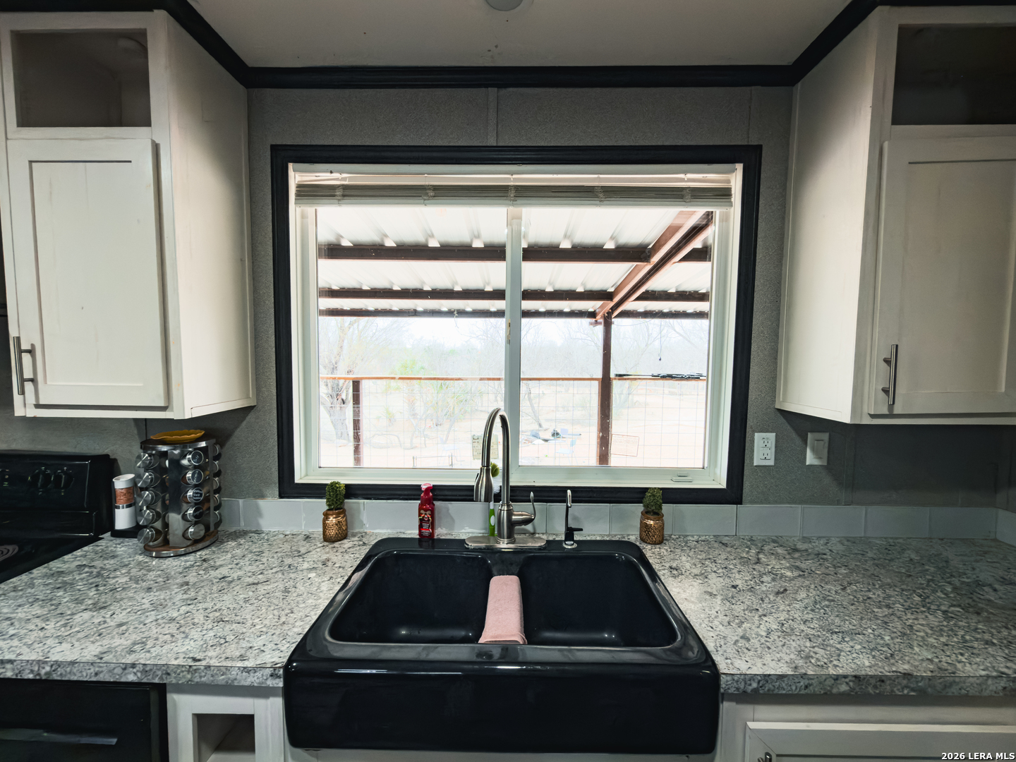 114 4th Street Natalia, TX 78059 - Photo 8 of 32 a kitchen with granite countertop a sink and a window