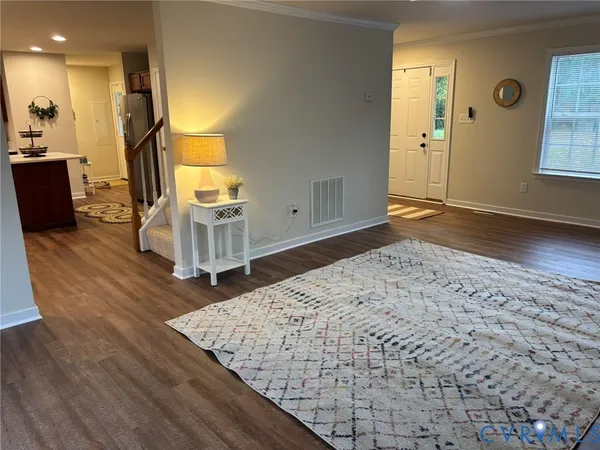 a view of a livingroom with wooden floor and stairs